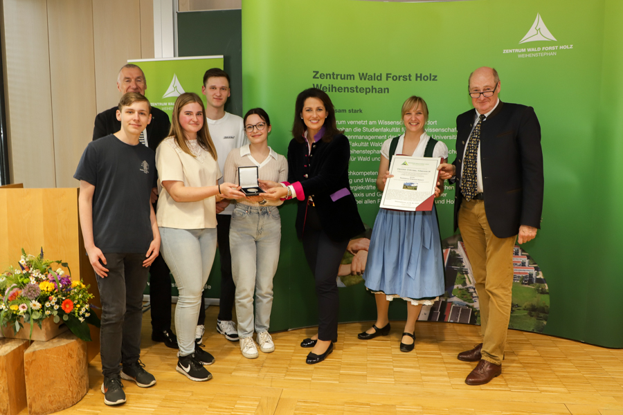 Staatsministerin Michaela Kaniber (3.v.r.), Prof. Dr. Reinhard Mosandl, Förderverein (r.) und Prof. Dr. Klaus Richter, Leiter des Zentrums Wald Forst Holz Weihenstephan (2. v.l.) überreichen die Georg-Dätzel-Medaille an das Schulprojekt Zukunftswald: (v.l.n.r.) Robin Beetz, Inga-Carina Zänker, Jonas Löffler, Michelle Betz und die Lehrerin Stefanie Springer. Foto: C. Josten, ZWFH